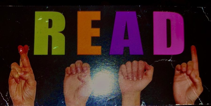 A bookmark from the school showing how to spell read in sign language.